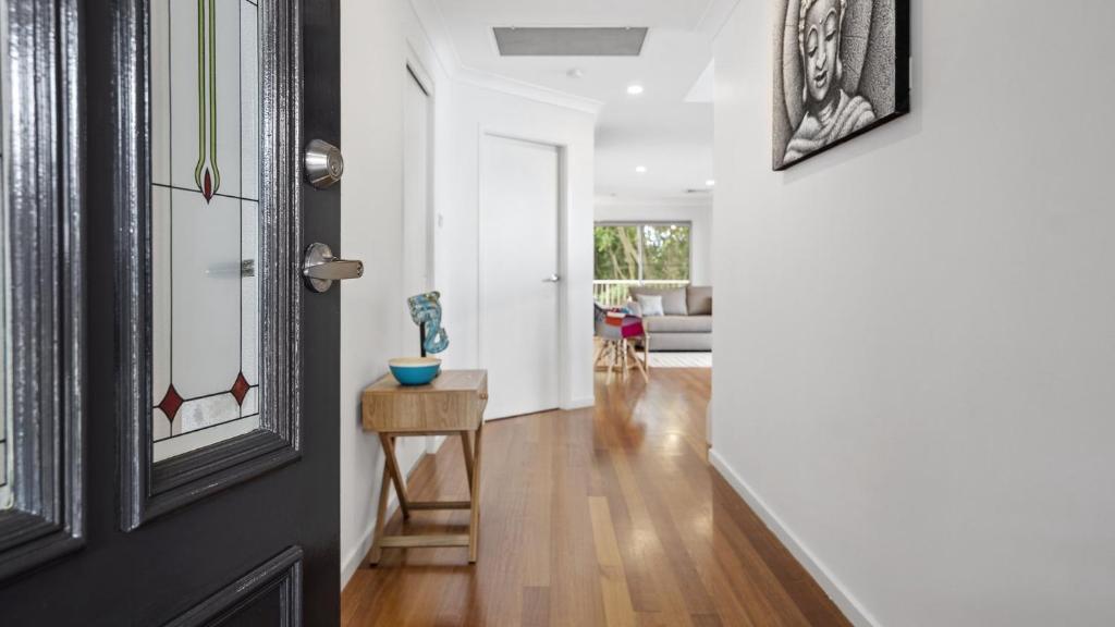 a hallway with white walls and a door with a table at New With A View Accom Holidays in Copacabana