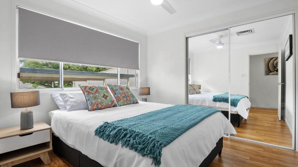a bedroom with a large bed and a mirror at New With A View Accom Holidays in Copacabana