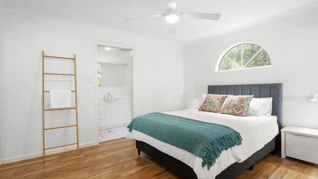 a white bedroom with a bed and a window at New With A View Accom Holidays in Copacabana