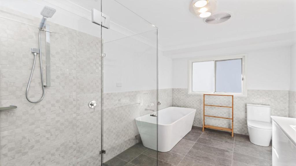 a bathroom with a shower and a tub and a sink at New With A View Accom Holidays in Copacabana