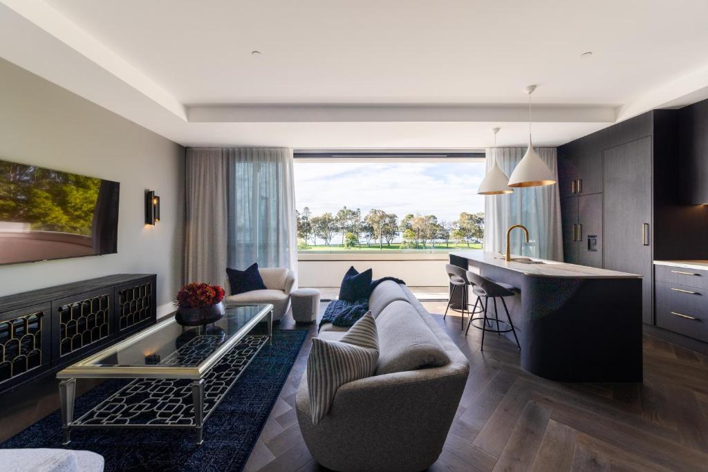 a kitchen and living room with a couch and a table at Balmoral on Scott - Harbour Front Perfection in Newcastle