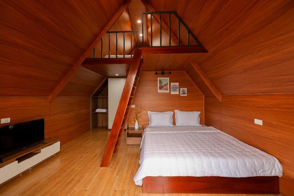 a bedroom with a large bed and a staircase at Homestay Mường Trời in Diện Biên Phủ