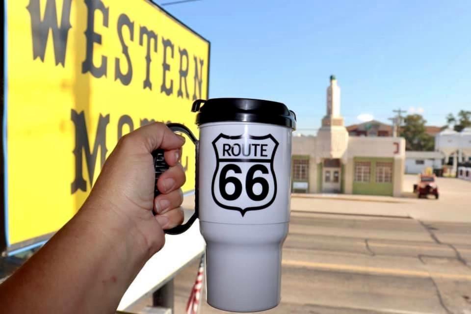 a persons hand holding a white and black coffee cup at Western Motel in Shamrock