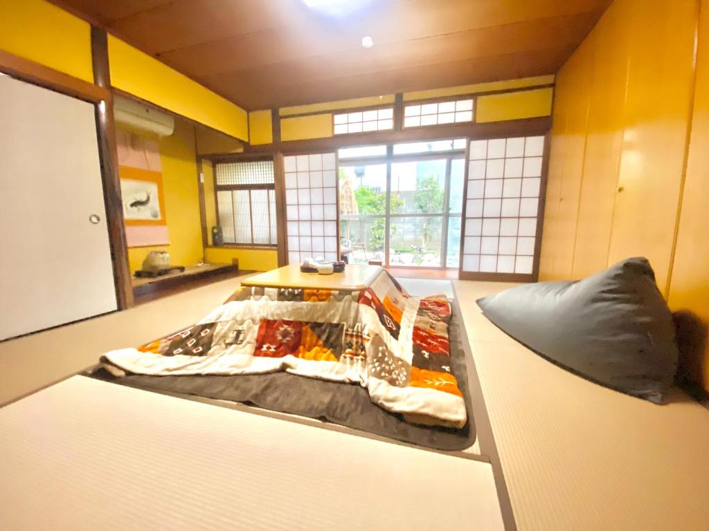 【天王寺駅まで電車4分】庭園付き一軒家ー杏 في أوساكا: غرفة عليها سرير وطعام