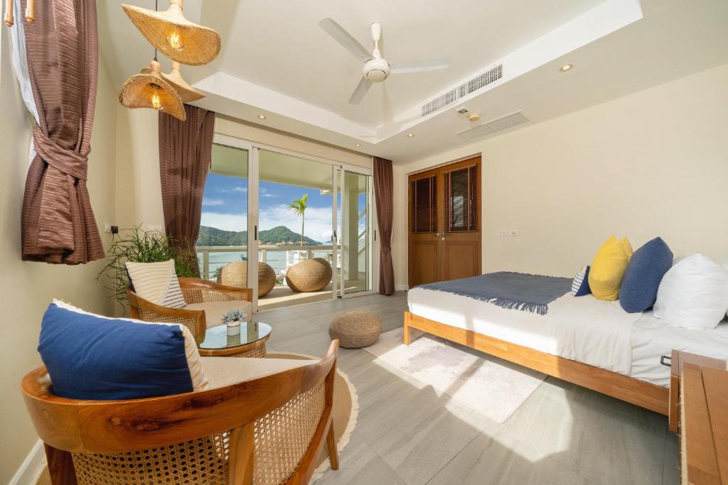 1 dormitorio con cama, sillas y balcón en Stunning 5 bedrooms Villa with Panoramic Sea View en Por Bay