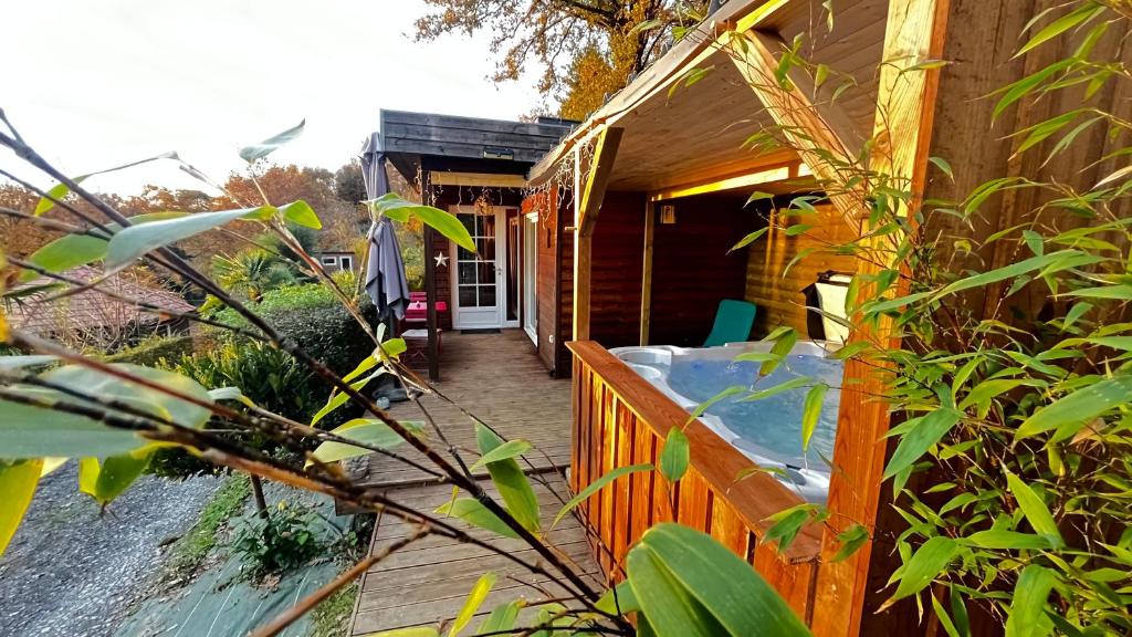 a wooden porch of a house with a deck at Chalet-studio Bien-Hetre in Fichous-Riumayou