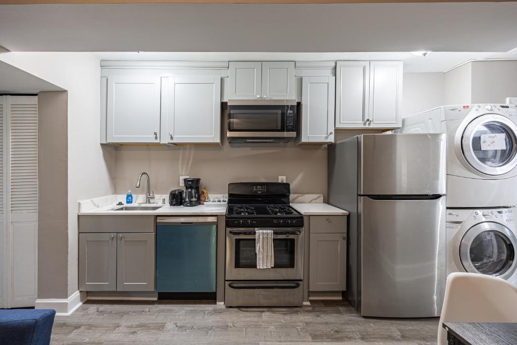 een keuken met witte kasten, een fornuis en een koelkast bij Modern Updated Condo Near Downtown in Washington