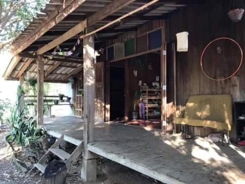 une maison en bois avec un banc devant elle dans l'établissement บ้านริมน้ำประตูม่าน, à Ban Wiang Nua