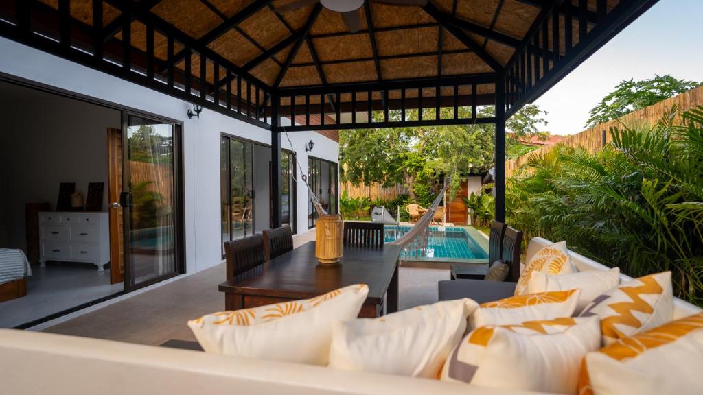 un patio al aire libre con mesa, sillas y piscina en Temple villas Koh Phangan, en Ko Pha Ngan
