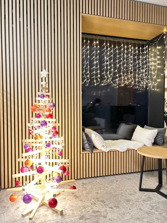 un árbol de Navidad en una sala de estar con cama en Stara lipa Tašner kitchen & P & garage - self check-in, en Maribor
