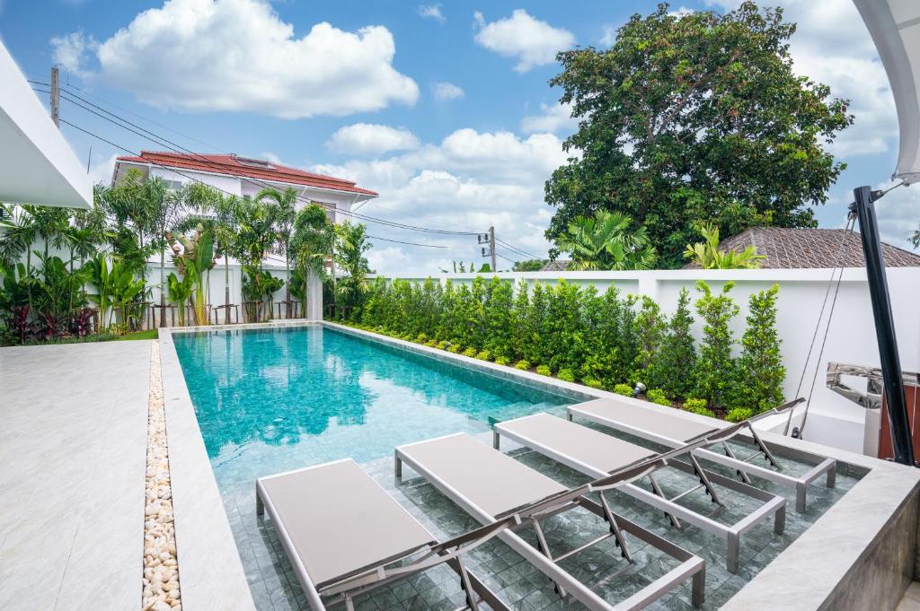 ラワイビーチにあるMango Hill Residenceのラウンジチェア付きのスイミングプールが隣接しています。