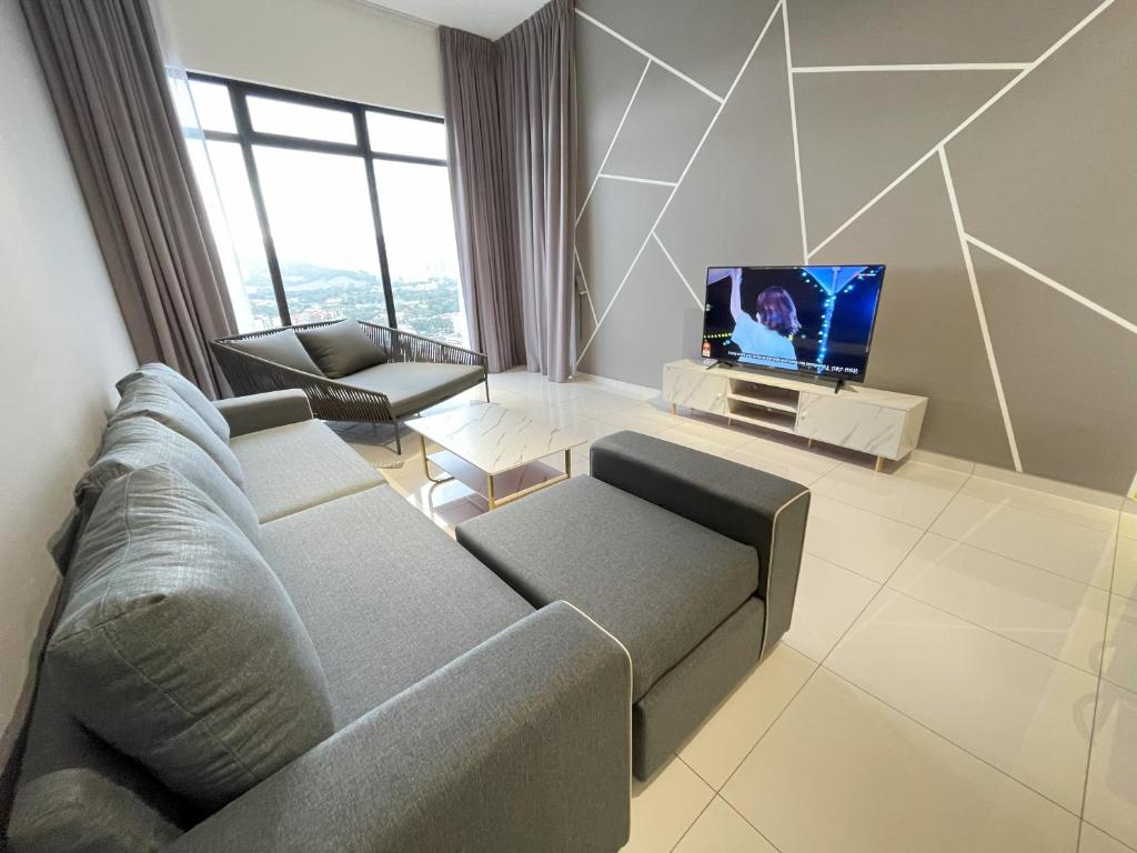 een woonkamer met een bank en een tv bij Penang Georgetown KT Home for 8 pax in George Town