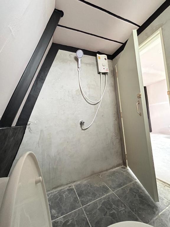 La salle de bains est pourvue d'une douche et de toilettes. dans l'établissement บ้านริมน้ำ สำหรับครอบครัว, à Buriram