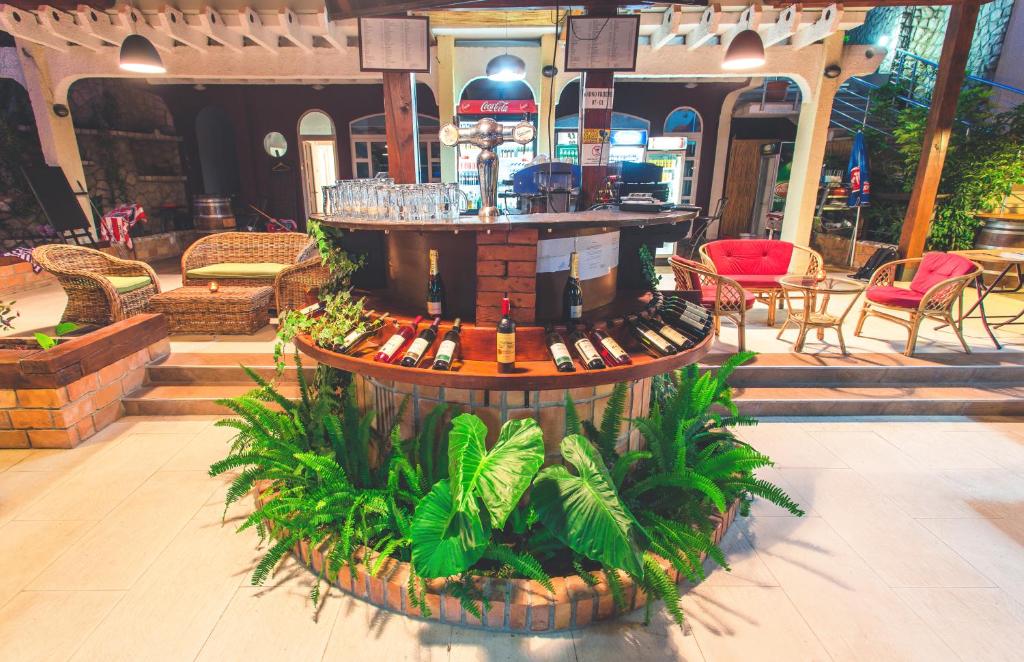 a drink fountain in a restaurant with tables and chairs at Apartments Deus in Dobra Voda