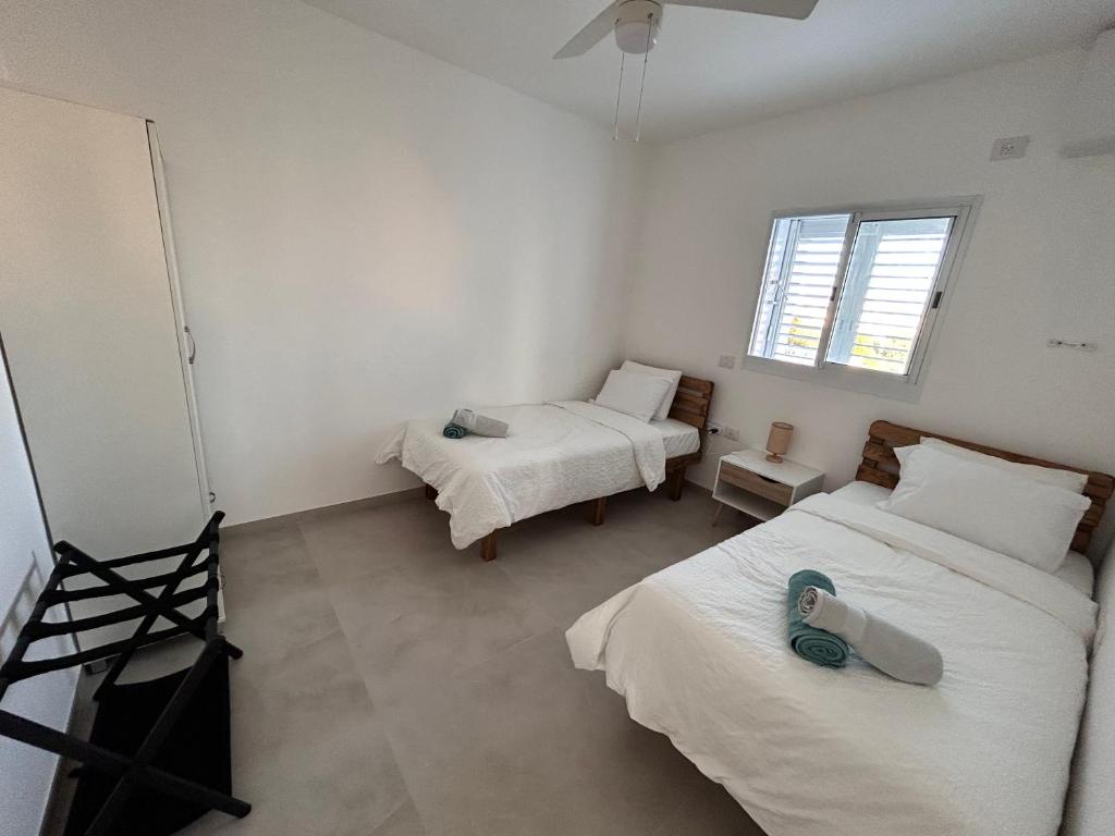 - une chambre avec deux lits et une chambre avec deux fenêtres dans l'établissement Sea Breeze Netanya Retreat by Sea N' Rent, à Netanya