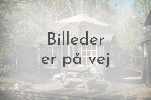 un ombrellone e una sedia seduti su un patio di Family-friendly House With A View Of The Fjord a Ølsted