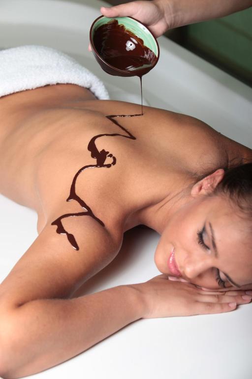 a woman getting a back massage with chocolate on her back at Flamingo Grand Hotel & Spa in Albena