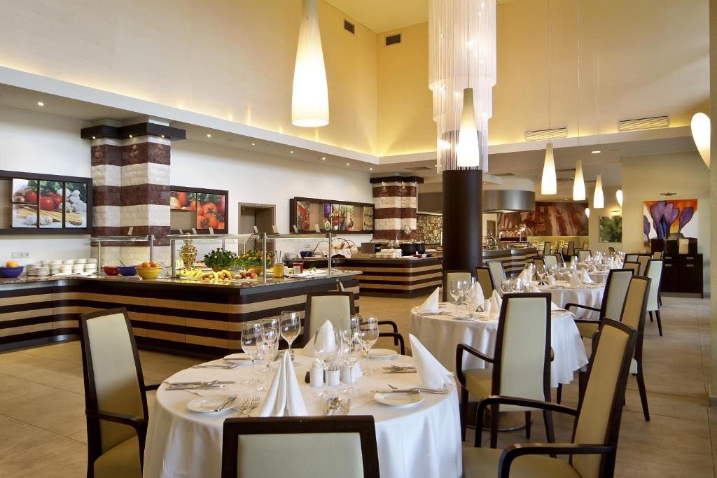a restaurant with white tables and chairs and a buffet at Flamingo Grand Hotel & Spa in Albena