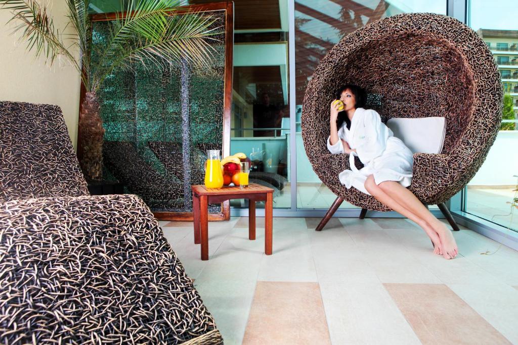 a woman sitting in a chair talking on a cell phone at Flamingo Grand Hotel & Spa in Albena