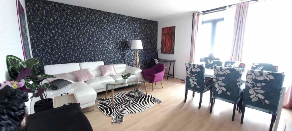 a living room with a white couch and a table and chairs at Armorino - Appartement Charmant 2 Chambres - Proximité de tout in Lannion