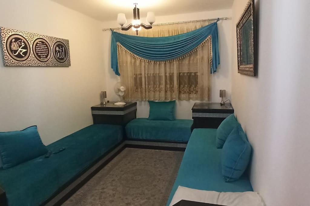 a living room with two blue couches and a window at Apartamento en Tetuán in Tetouan