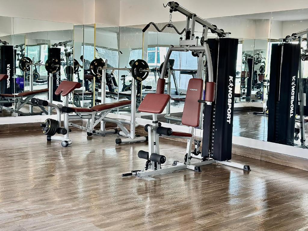 A resistance-training corner with a multi-station machine, benches and mirrored walls.