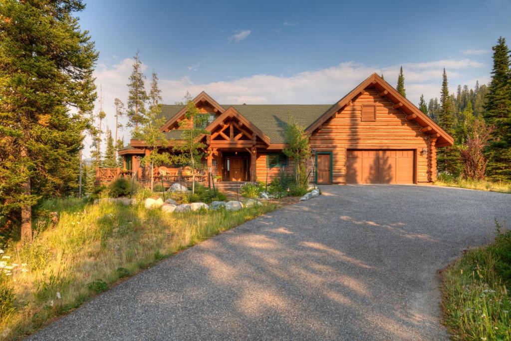 una casa de madera con una carretera delante de ella en MV Leaf Lodge, en Big Sky