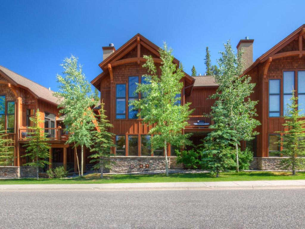 a large wooden house with trees in front of it at Black Eagle 10 in Big Sky