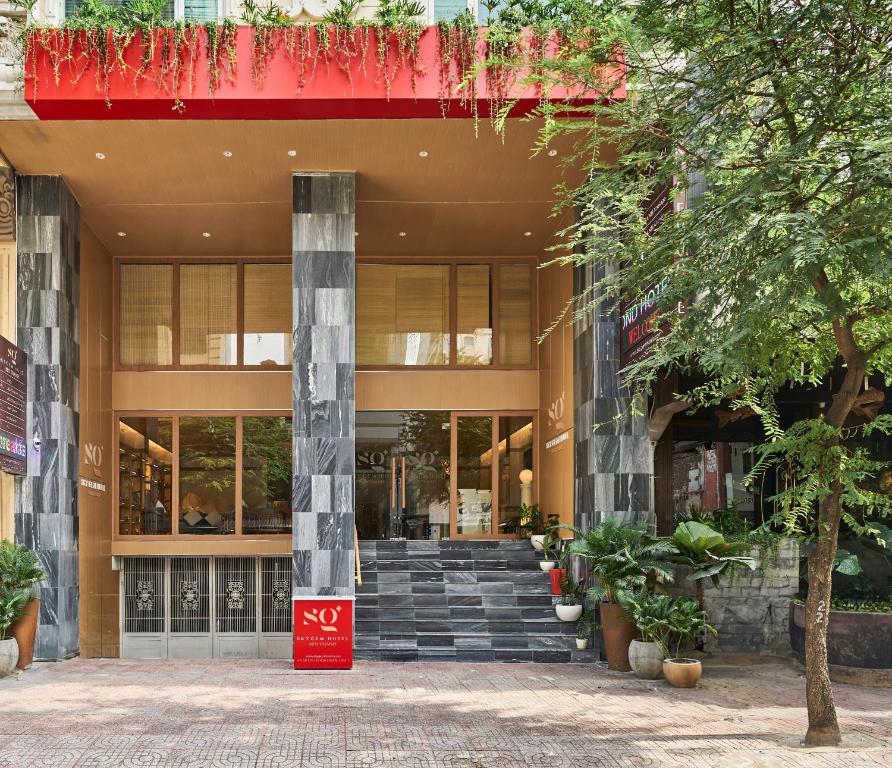 胡志明市的住宿－Sky Gem Hotel - Ben Thanh，前面有红色标志的建筑