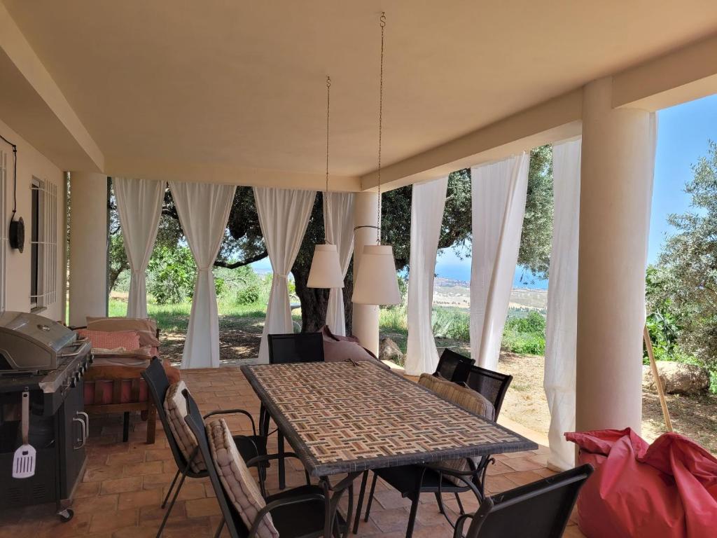 ein Esszimmer mit einem Tisch und Stühlen in der Unterkunft Seele baumeln lassen im Olivenhain (Meeresnähe) in Santa Caterina dello Ionio