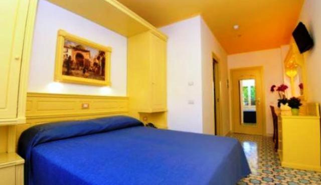 1 dormitorio con 1 cama azul en una habitación en Hotel Astoria Sorrento en Sorrento