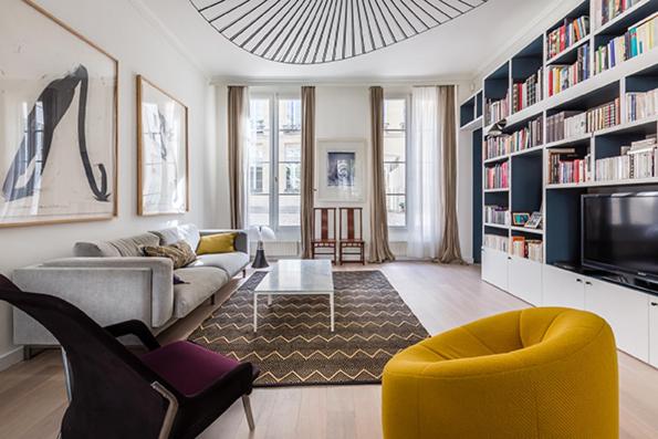 a living room with a couch and a tv at Veeve - Square du Temple Comfort in Paris