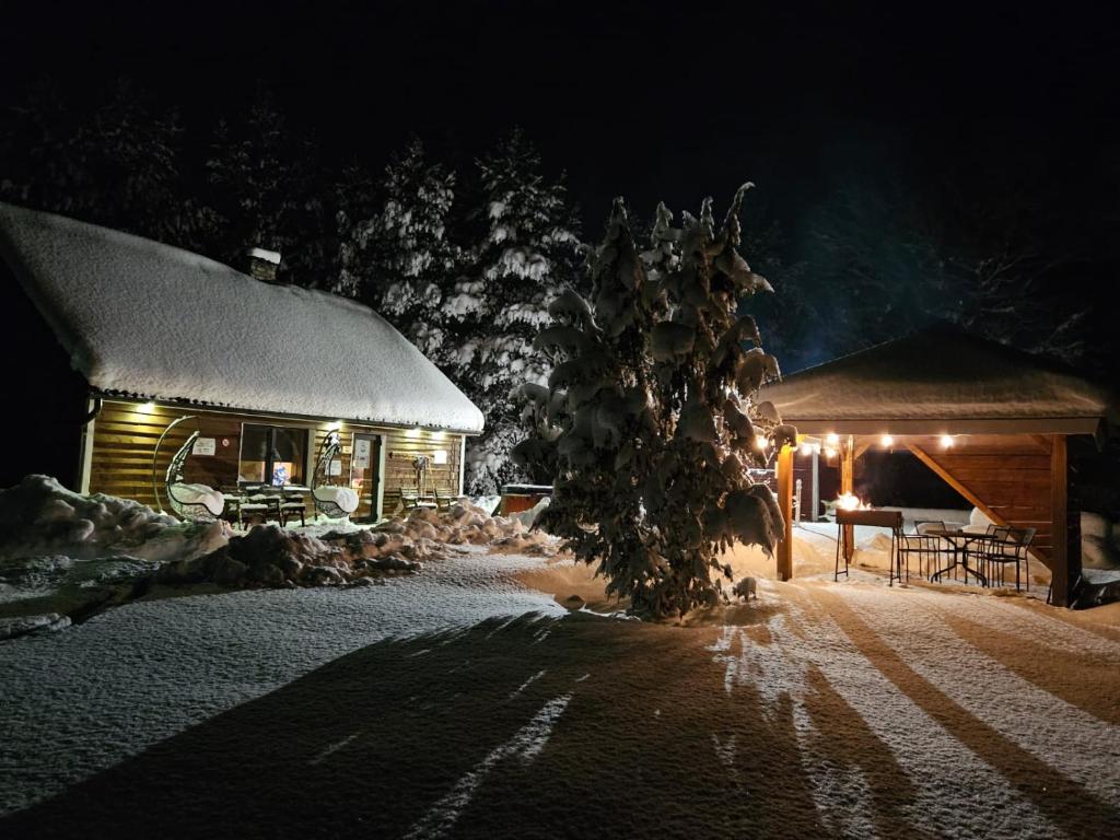 une cabane en rondins dans la neige la nuit dans l'établissement Sämi Siil, à Sämi