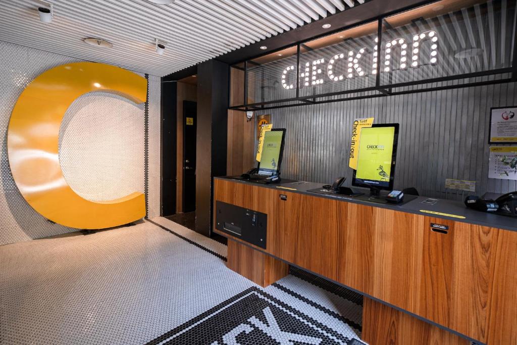 a lobby with a reception desk with a sign on the wall at CHECK inn Taipei Songjiang in Taipei