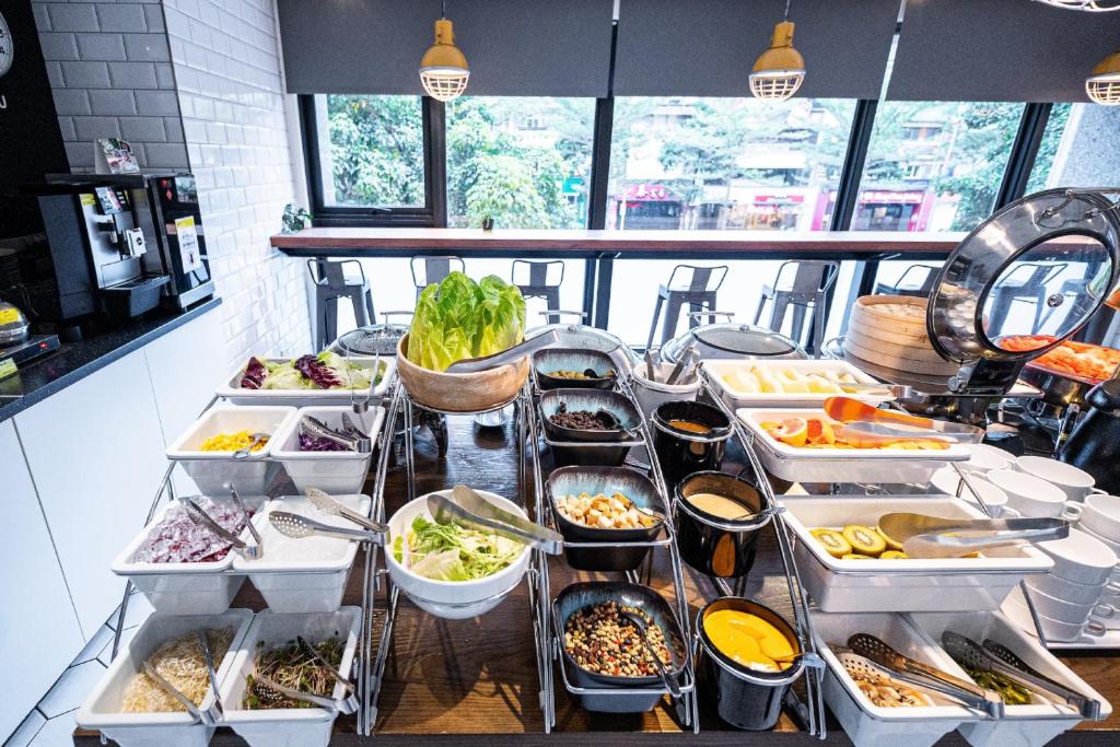 a buffet with many trays of food on a table at CHECK inn Taipei Songjiang in Taipei