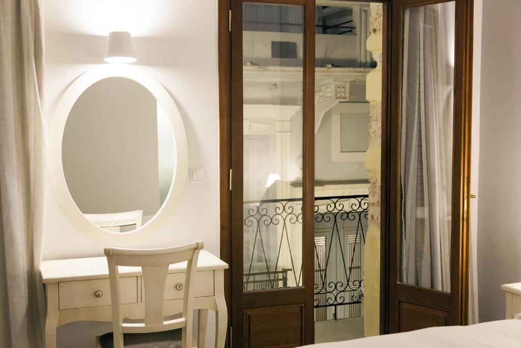 um quarto com um espelho, uma mesa e uma cadeira em Shalom Luxury Rooms Kondilaki em Chania