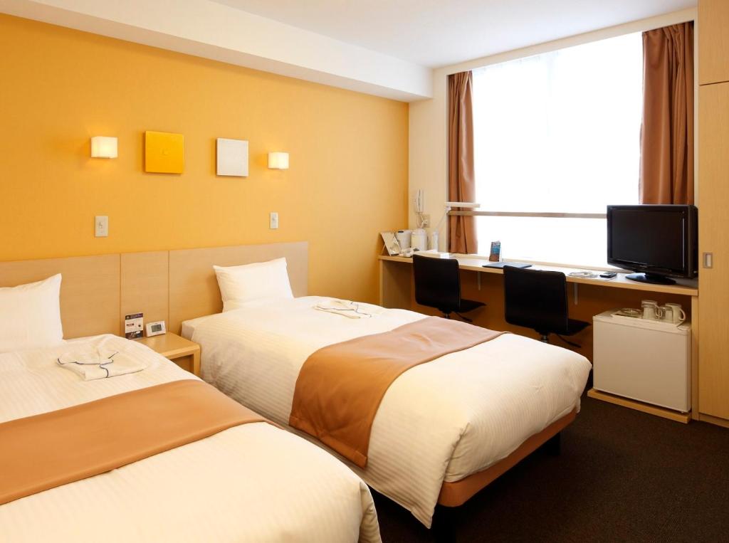 Postel nebo postele na pokoji v ubytování Quad Inn Yokote