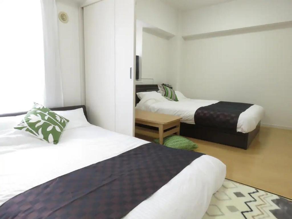 a hotel room with two beds and a room with two beds at カナン中央町A館 in Kagoshima