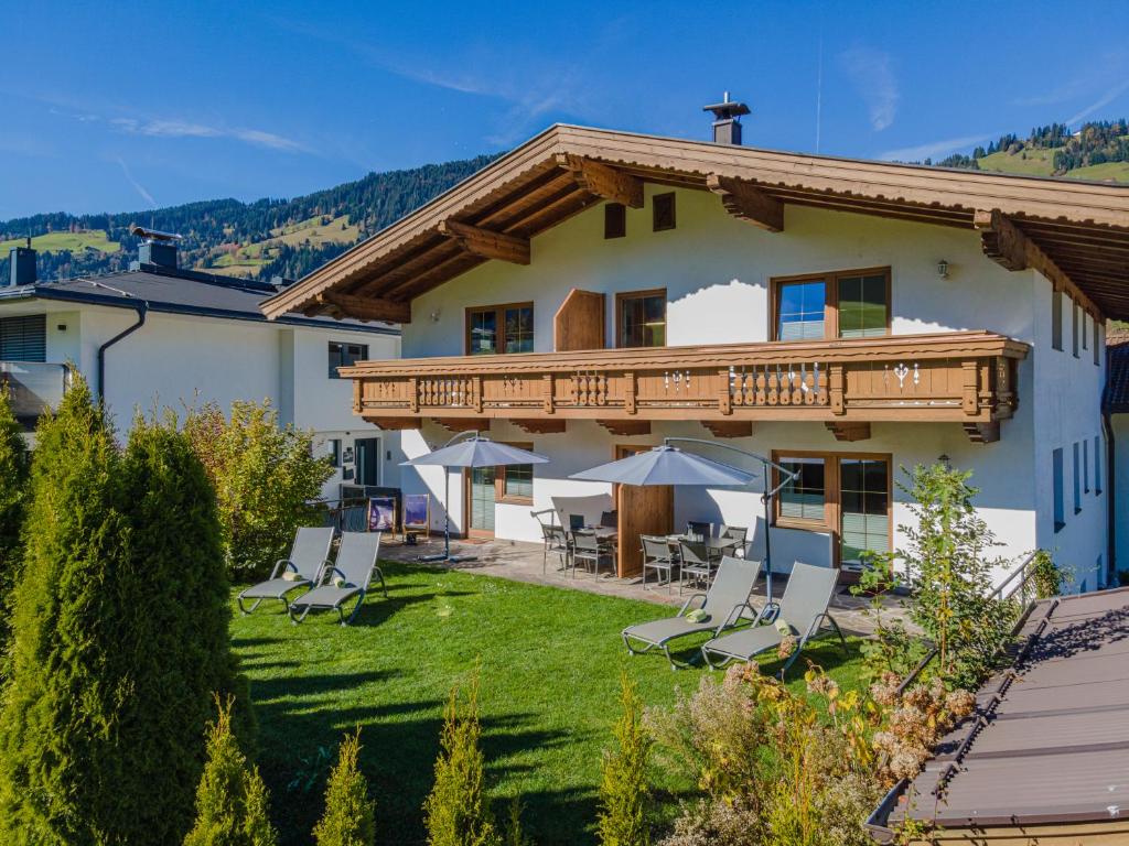 ein Haus mit einer Terrasse und Stühlen im Hof in der Unterkunft Appartement Gamper in Brixen im Thale