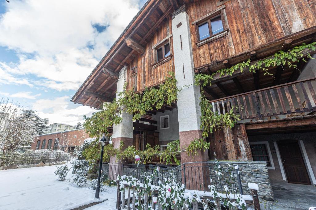 una casa in legno con dei fiori di fronte di Chalet d'Aoste ad Aosta