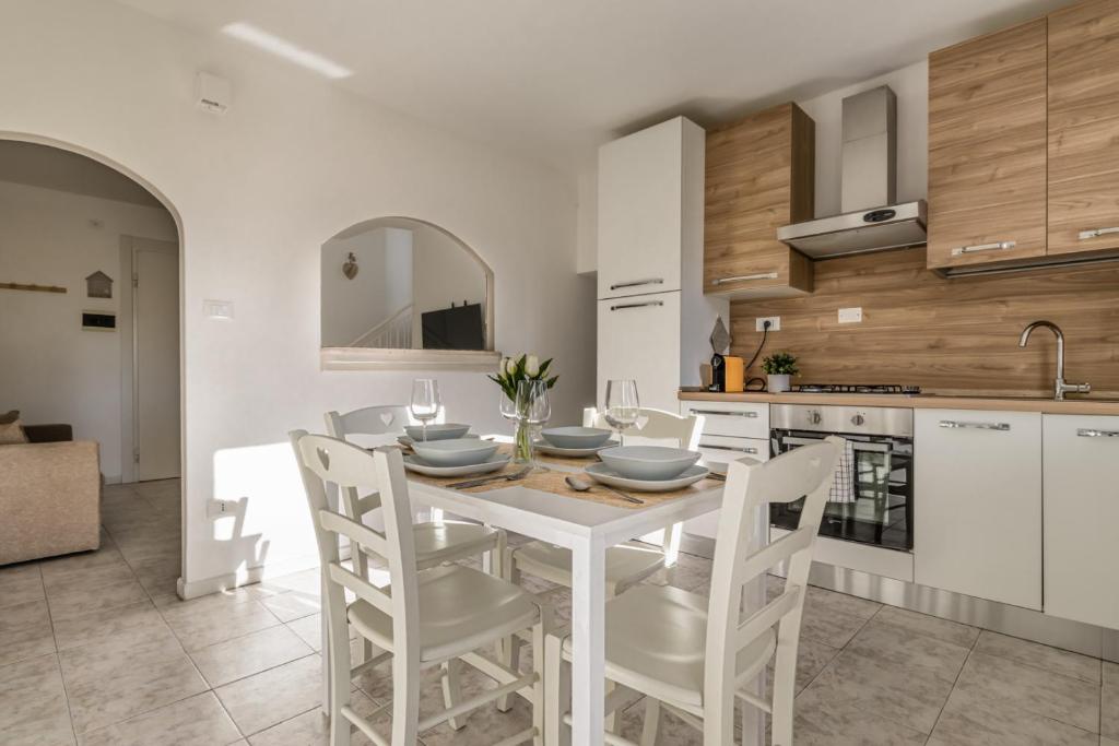 eine Küche mit einem weißen Esstisch und Stühlen in der Unterkunft 45 minutes to Venice - By Flora in Fagarè della Battaglia