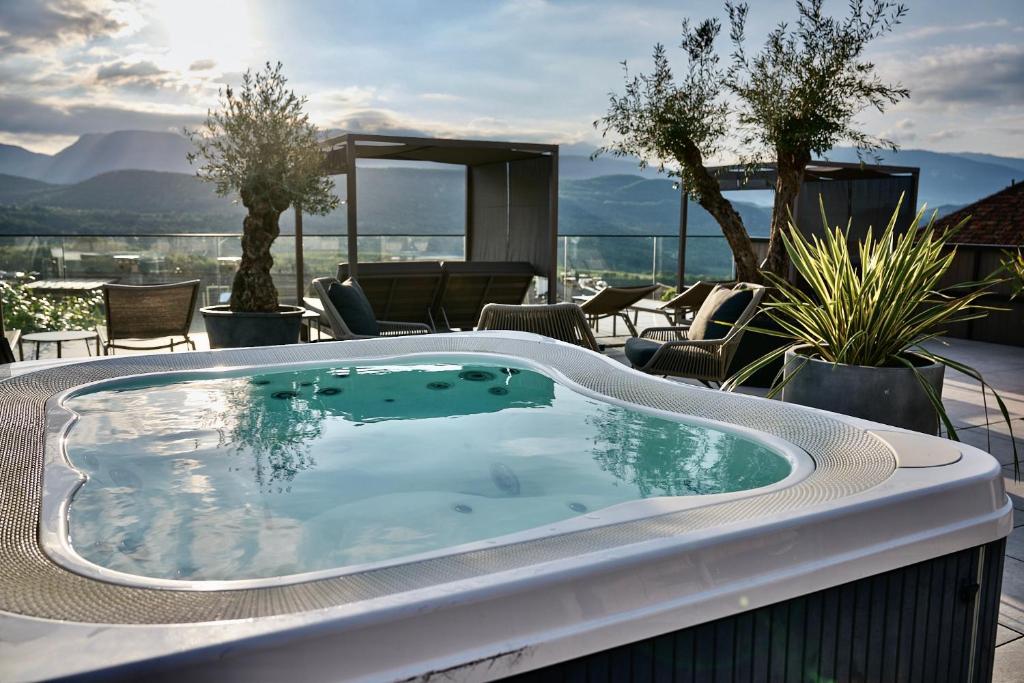 a jacuzzi tub on a patio with chairs at Das Panorama Dependance in Caldaro