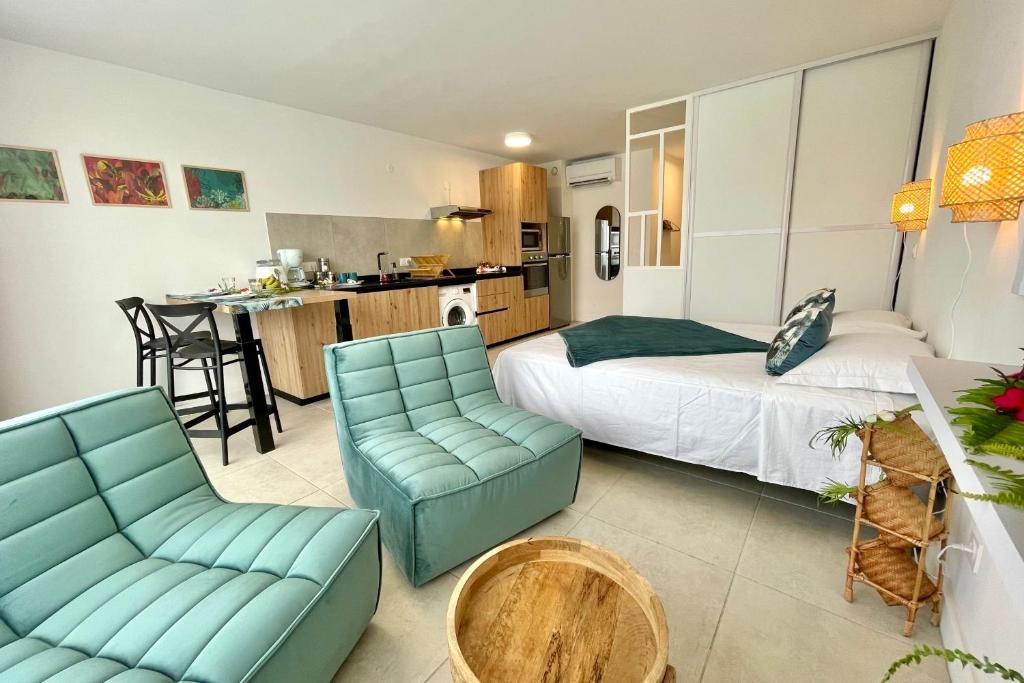 a bedroom with a bed and chairs and a kitchen at Studio Hanalei City brand new in the center of Papeete WiFi -Netflix -AC in Papeete
