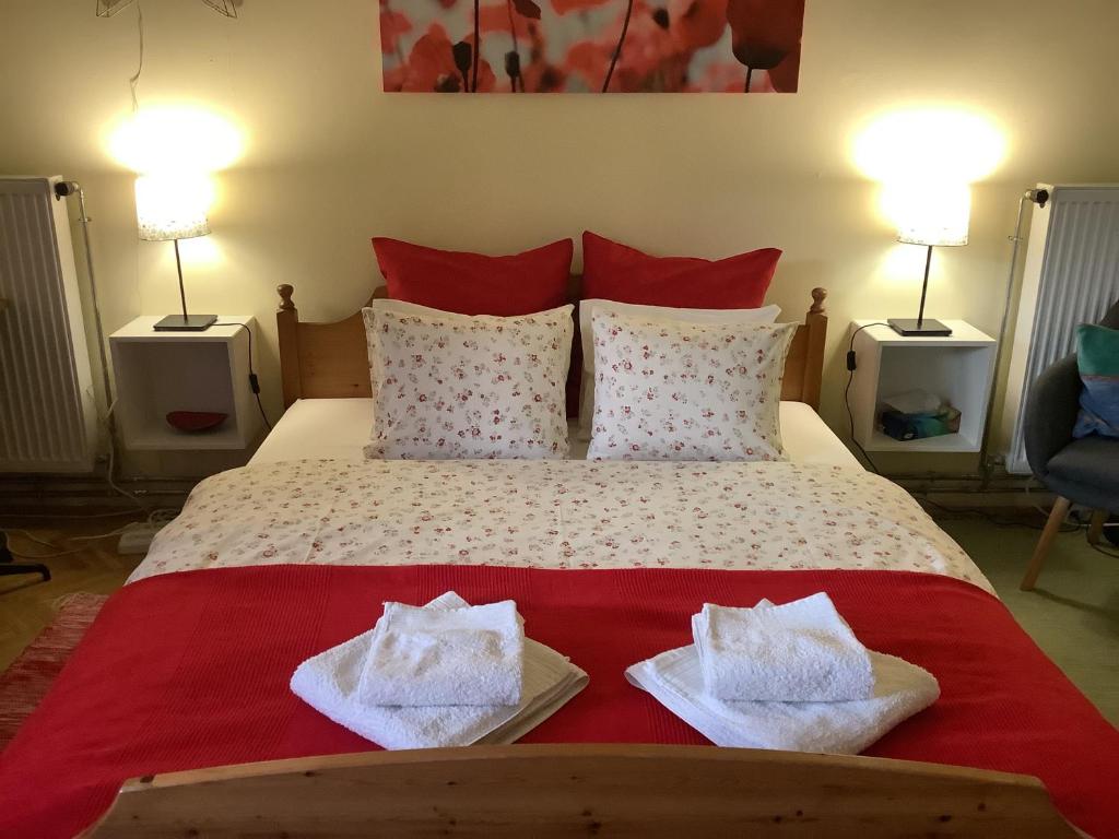 a bedroom with a bed with two towels on it at Poppy Flower Apartment in Budapest