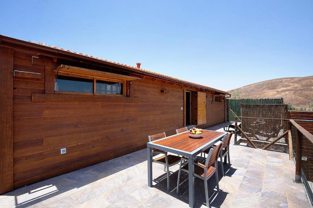 a patio with a table and chairs and a building at La Casita de Vidal in Tuineje