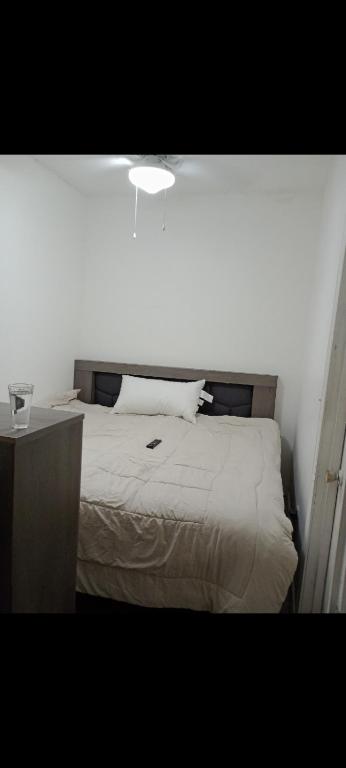 ein Schlafzimmer mit einem weißen Bett und einem Nachttisch in der Unterkunft Apartamento Puente del zorro in Ciudad Juárez