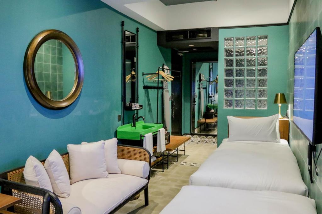 a room with two beds and a mirror at The Payang Hotel in Kuala Terengganu