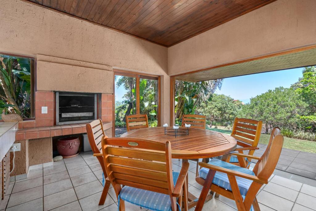 a dining room with a wooden table and chairs at San Lameer Villa 12405 - 2 Bedroom Classic - 4 pax - San Lameer Rental Agency in Southbroom