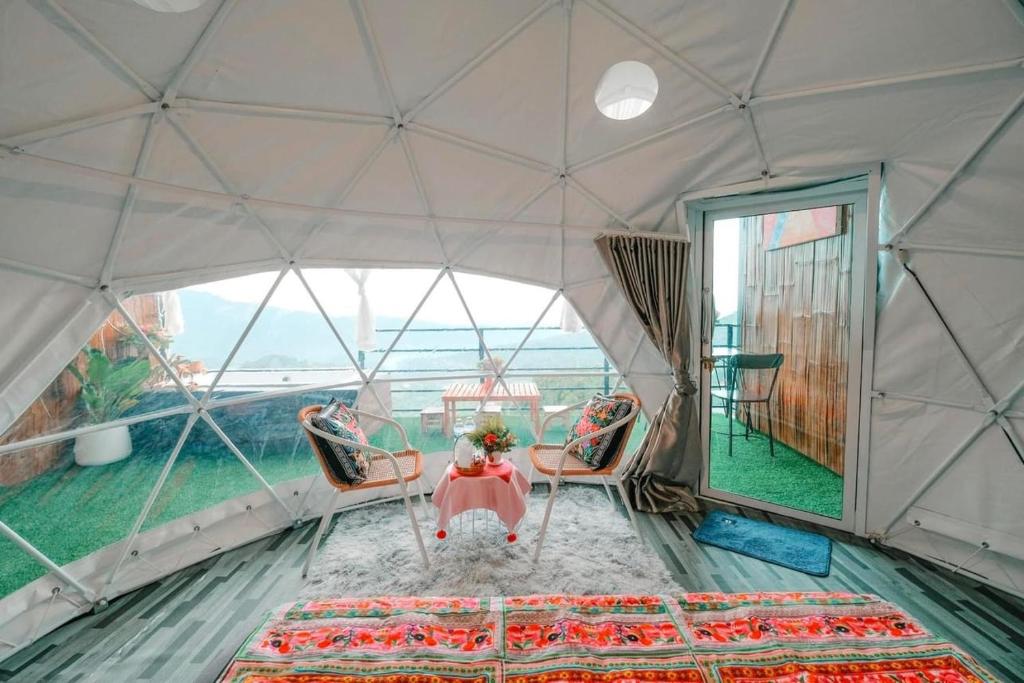 una habitación con mesa y sillas en una yurta en ม่อนสาเคียงดาว 