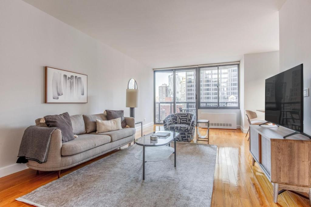 a living room with a couch and a tv at Midtown 2br w doorman nr theater district NYC-1349 in New York